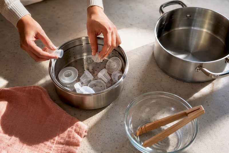 Hands sanitising separated breast pump parts