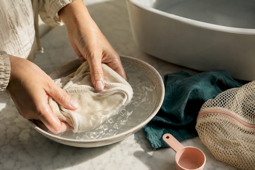 Hands rinsing reusable breast pads