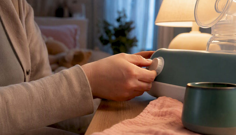 Mother adjusting breast pump suction setting