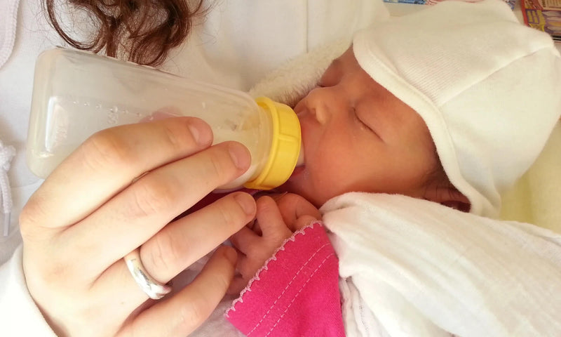 Lady bottle feeding a baby