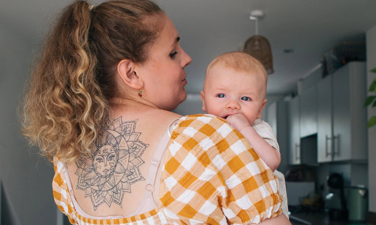 A Mum holding her baby who is looking over her shoulder