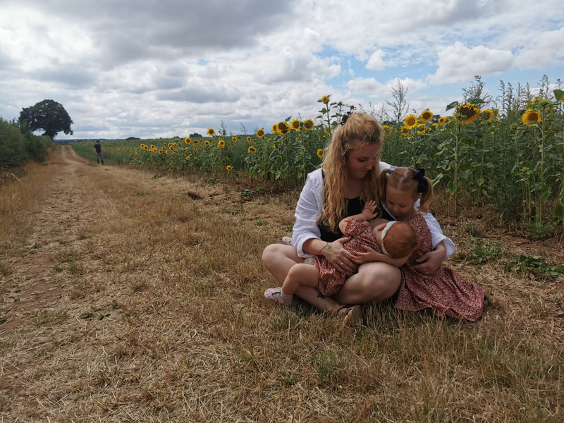 Women sitting down with her child in a field