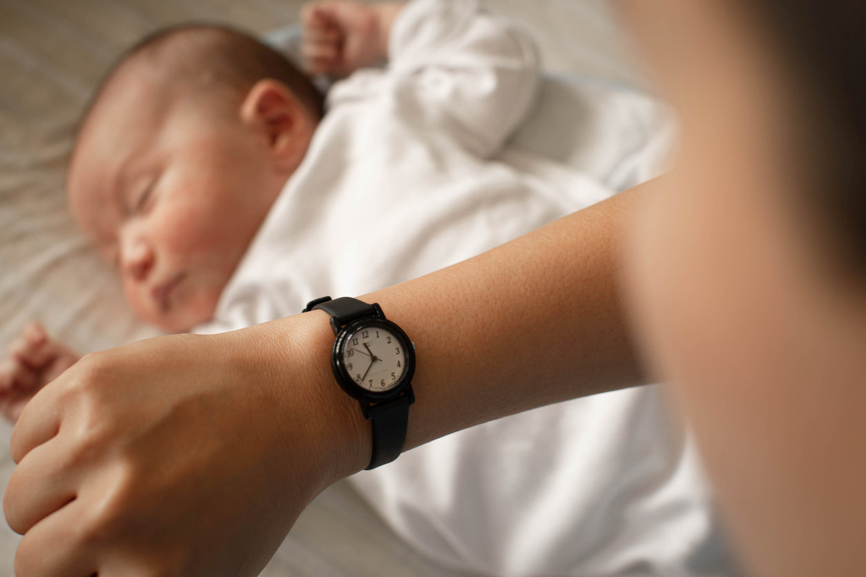 Sleeping baby and a women looking at her watch