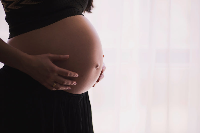 A woman touching her pregnant belly 